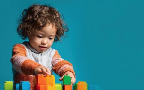 a-cheerful-toddler-builds-with-colorful-blocks-enjoying-creative-playtime-and-learning-photo